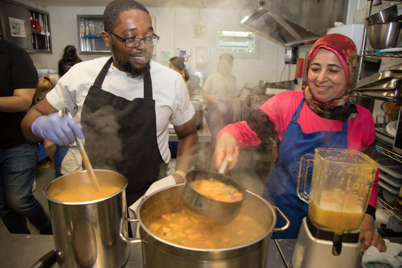 TR9YKG Volunteers at a community kitchen prepare a meal for diners in need.